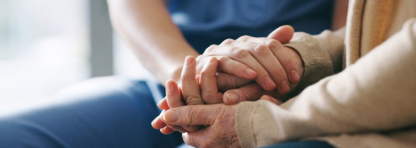 Two hands holding gently in a caring gesture.