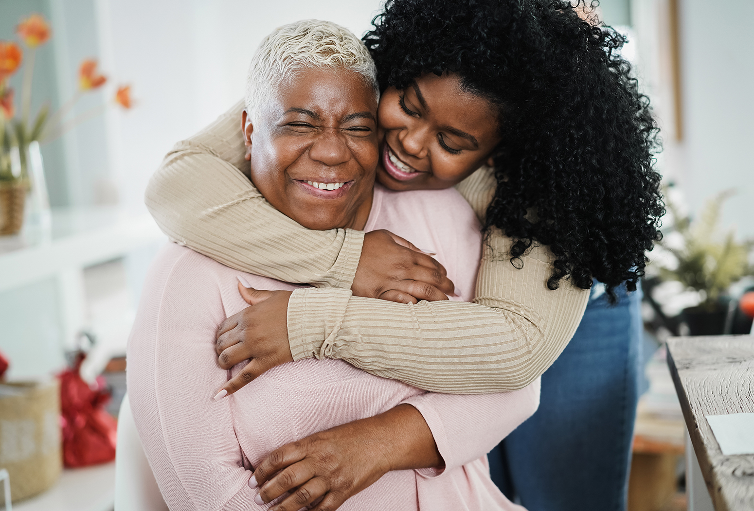 Two women embracing and smiling happily together.